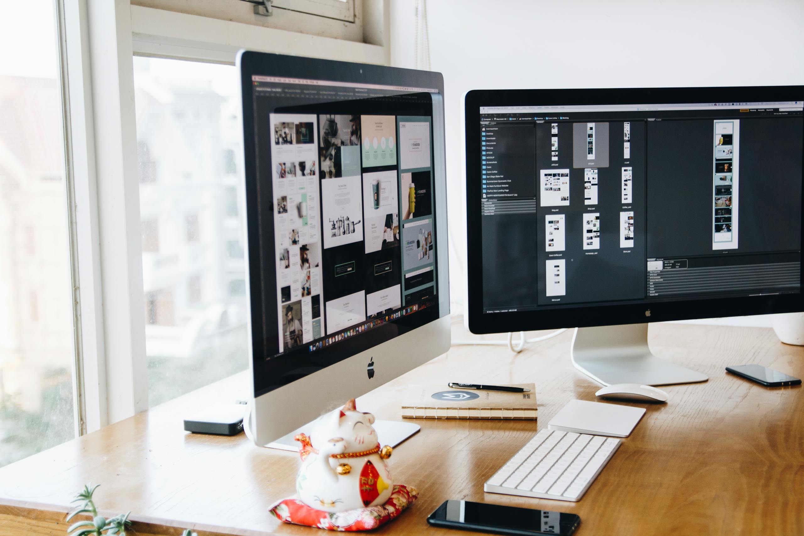 A sleek modern office setup featuring dual monitors, Apple devices, and creative decor in an indoor workspace.