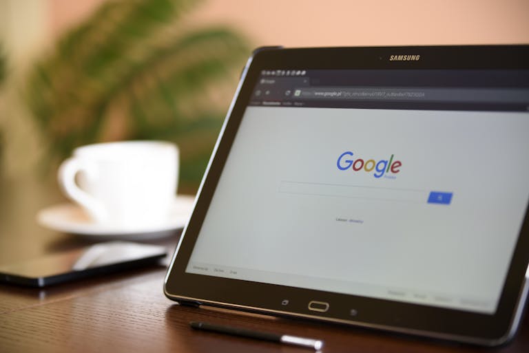 Samsung tablet on desk showing Google homepage, perfect for technology-related content.